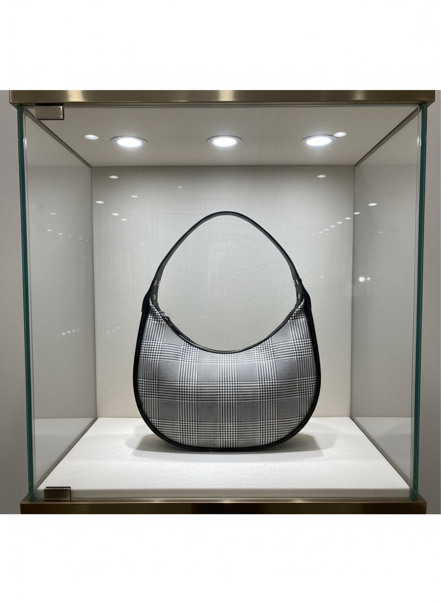 Crescent shaped bag with zipper closure.  Glenellen plaid and black water resistant canvas interior with interior zipper pocket.