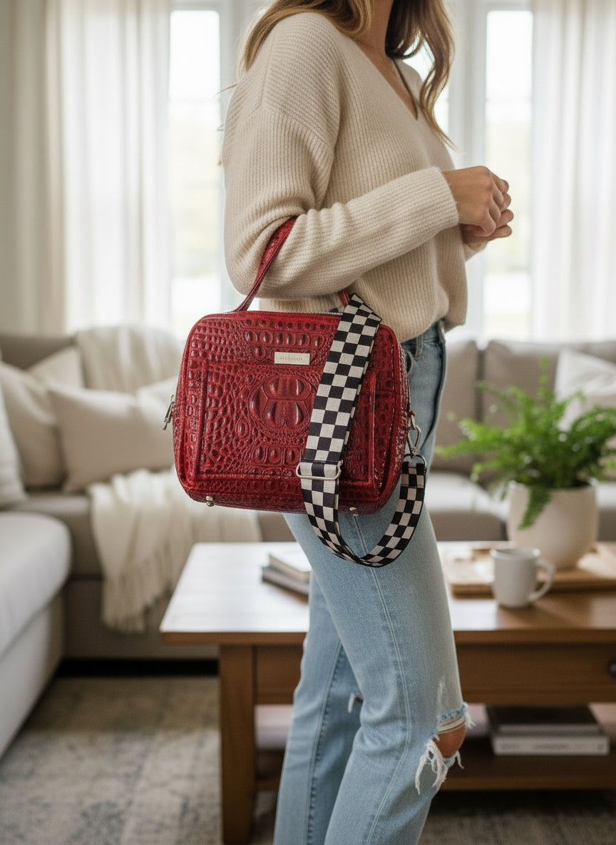 Red Crocodile bag with front pocket with magnetic flap, back zippered pocket and doubled zippered main compartment with zebra print water resistant canvas.  Accented with skull zipper pulls in silver