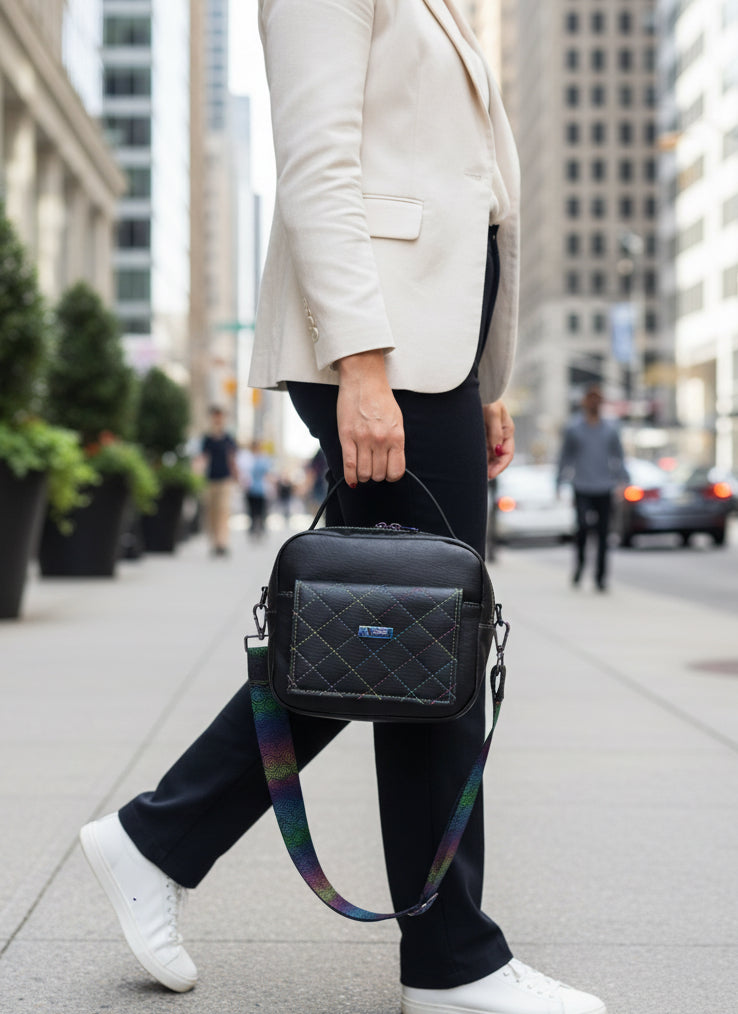 Black bag with front pocket with magnetic flap, back zippered pocket and doubled zippered main compartment with water resistant canvas.  Accented with with rainbow stitching, rainbow hardware and adjustable 1.5" shoulder strap